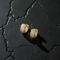 Aferando anti-tarnish gold huggie hoop earrings with three rows of American diamond stones, on dark stone
