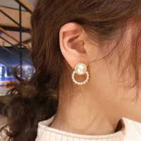 Aferando Gold Plated Korean Style Big Pearl Huggie Small Pearl Circle Hoop Stud Earrings, a unique and elegant piece of jewelry for women.