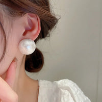 Aferando's White Oversized Uneven Texture Pearl Statement Stud Earrings for Women, beautifully crafted in gold plated material with a big size white pearl for a luxurious look.